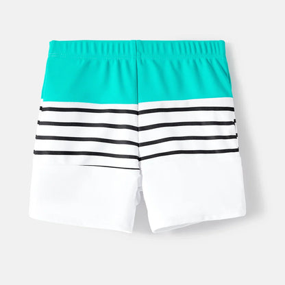 Full view of family matching striped swimwear against a bright summer background