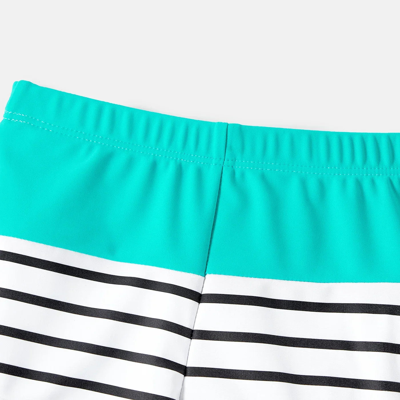 Close-up of the striped pattern on family swimwear, featuring classic blue and white