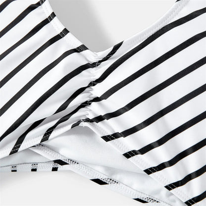 Coordinated striped swimwear highlighting a family enjoying a summer day by the water
