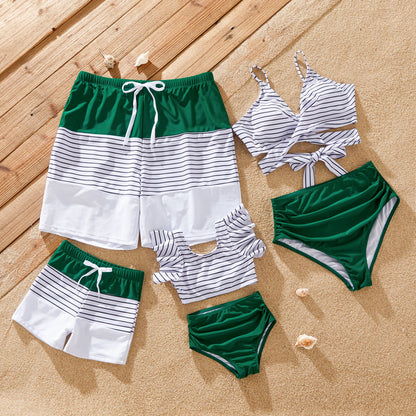 Family matching striped swimsuits in green for summer vacation fun by the beach