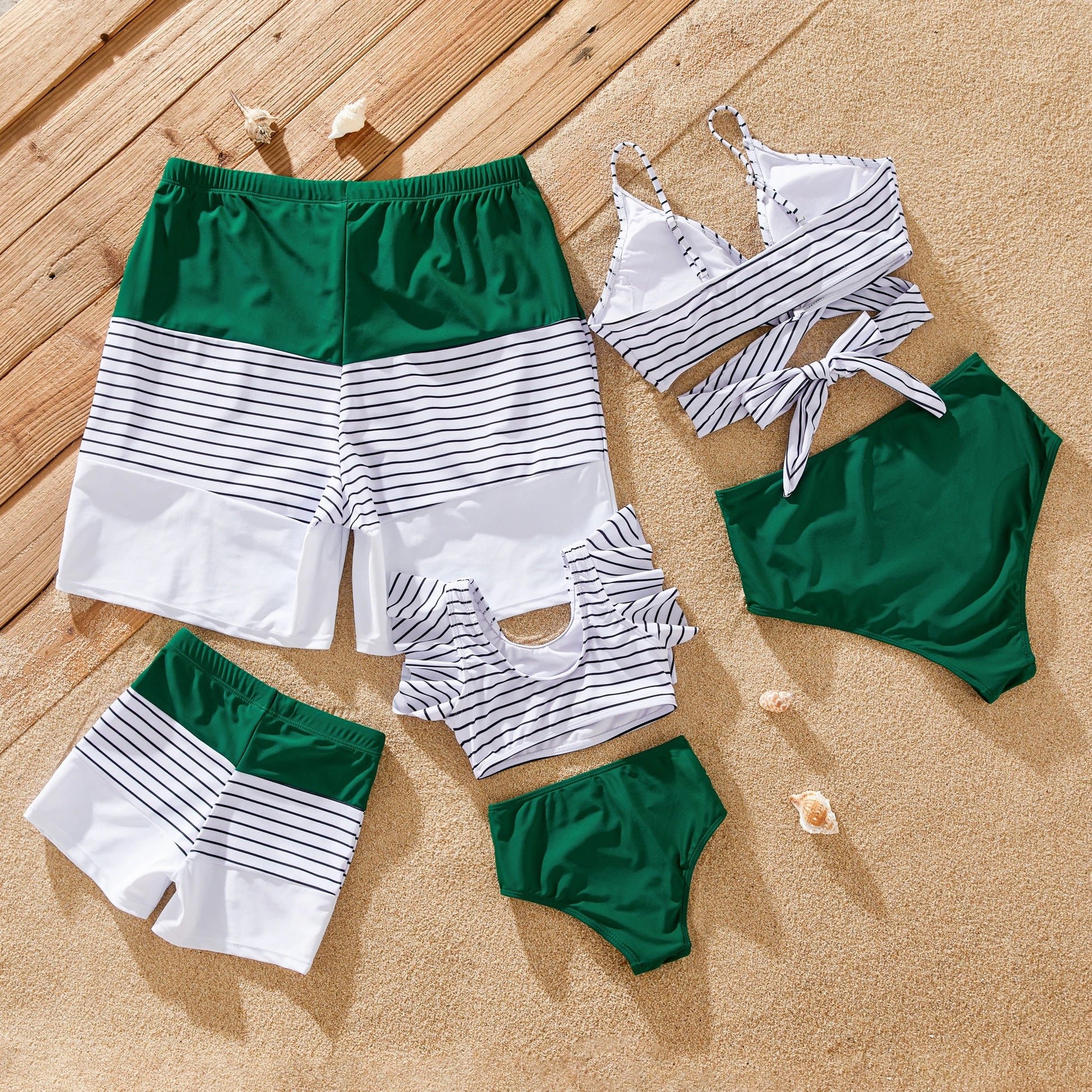 Mom, dad, and child wearing green striped matching swimwear for family beach day