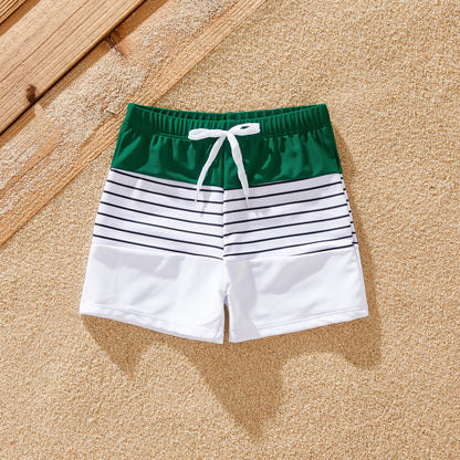 Family in stylish green striped swimsuits enjoying summer holiday by the pool