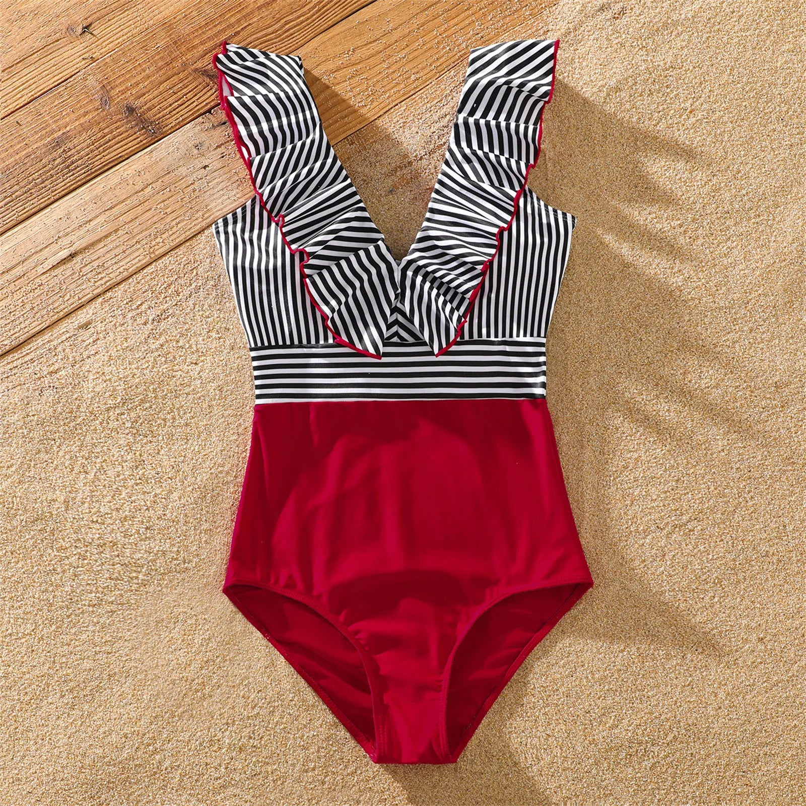 Full shot of family in striped swimsuits, enjoying summer vacation in matching outfits.