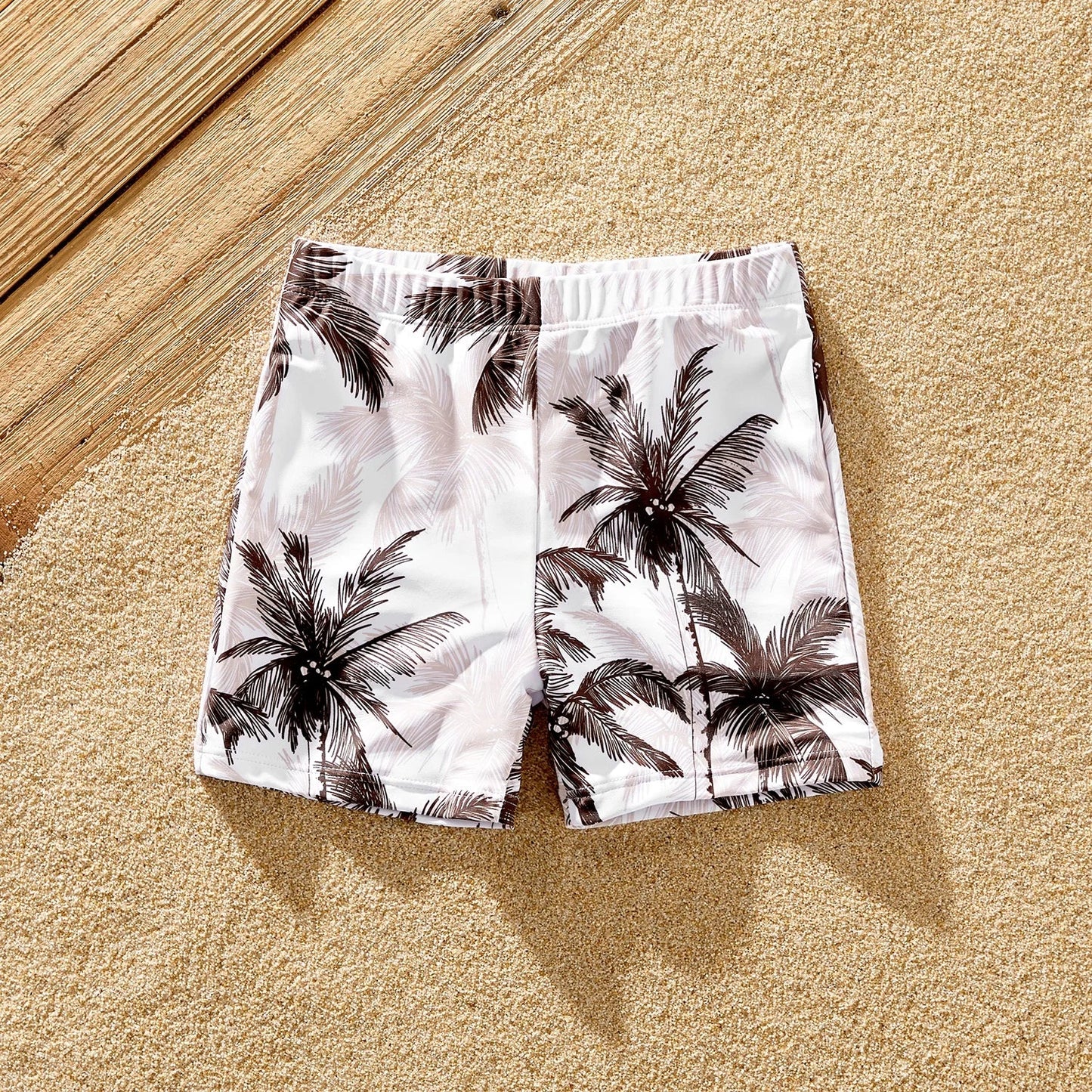 Family matching swimwear collection with vibrant coconut tree print, ideal for a tropical holiday