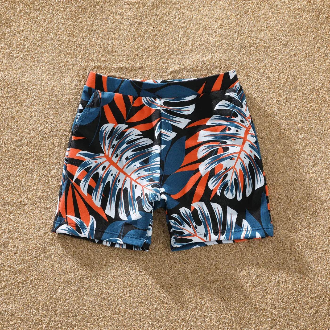 Family matching swimsuits with stylish palm leaf pattern for a fun pool day