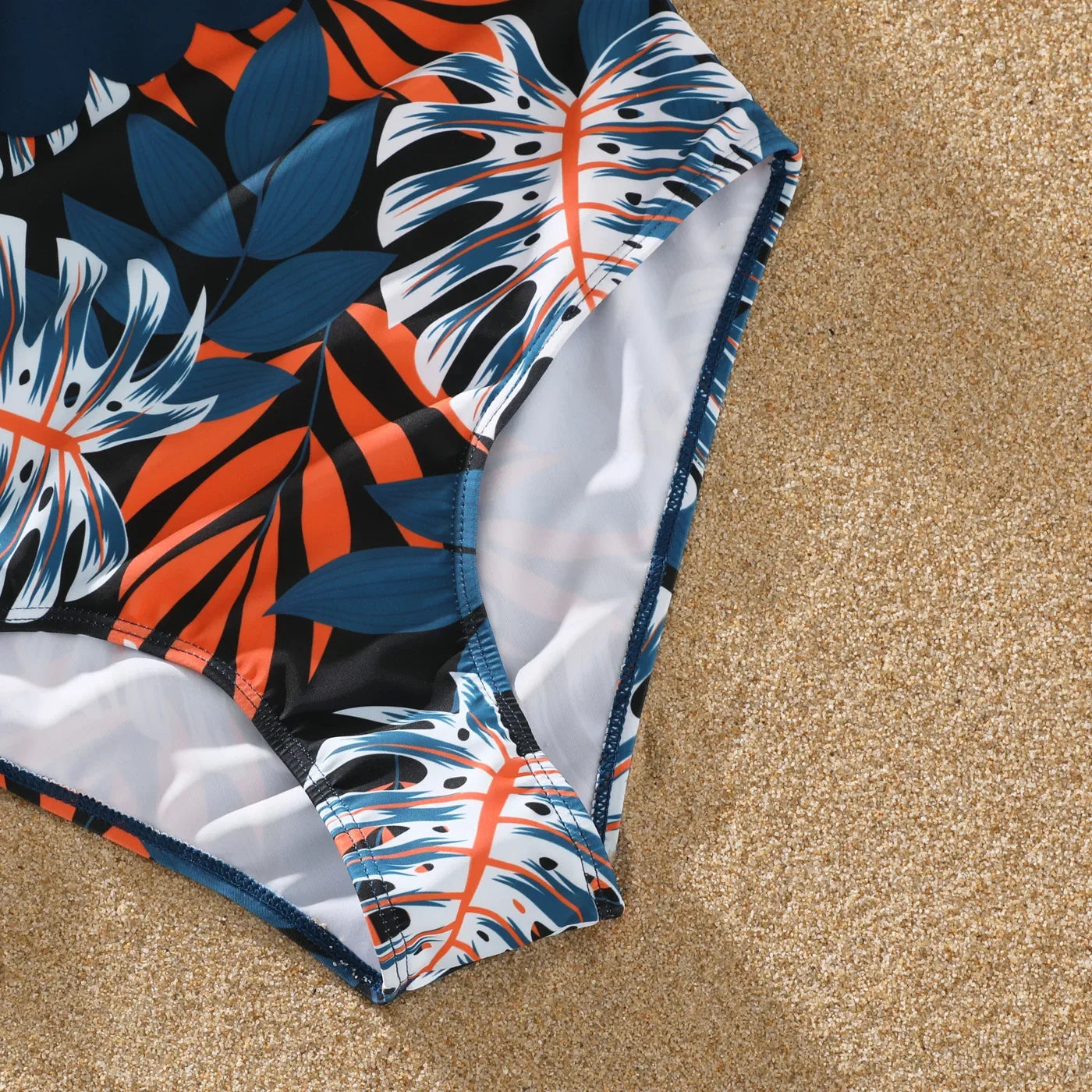 Infant in cute palm leaf print swimwear, part of family matching outfits