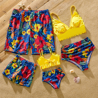 Family matching swimwear set featuring a women's scallop trim swimsuit and men's floral swim trunks.