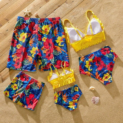 Stylish scallop trim swimsuit alongside floral print swim trunks for a cohesive family look.