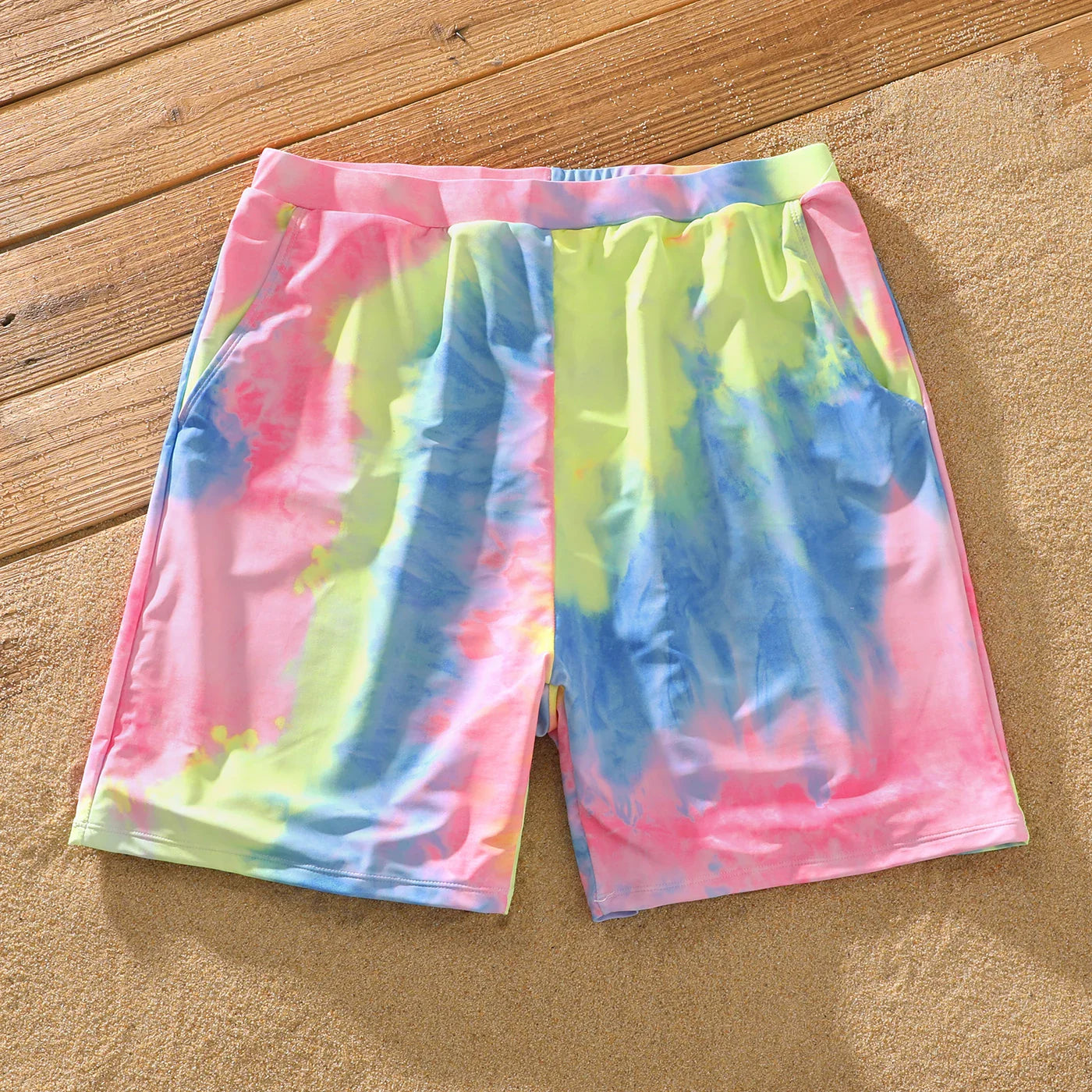 Happy family portrait in their new tie-dye matching swimsuits by the ocean
