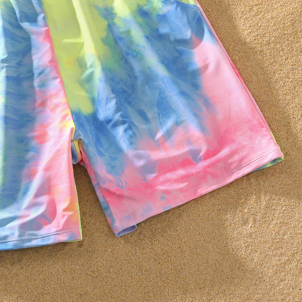Collection of tie-dye swimsuits for the whole family, including one-piece and trunks