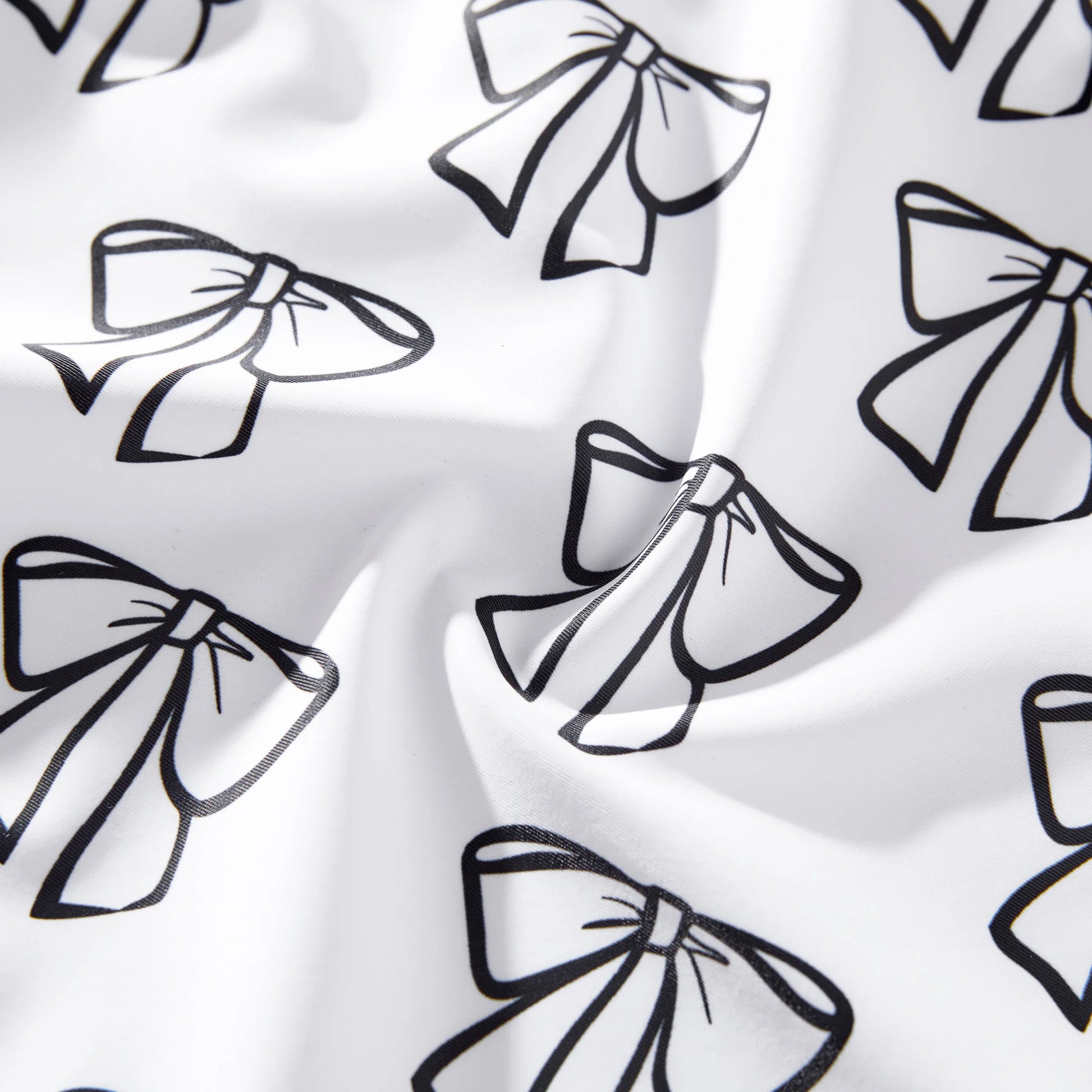 Matching white swimwear set featuring a bow detail on the ladies' suit and practical drawstring trunks.