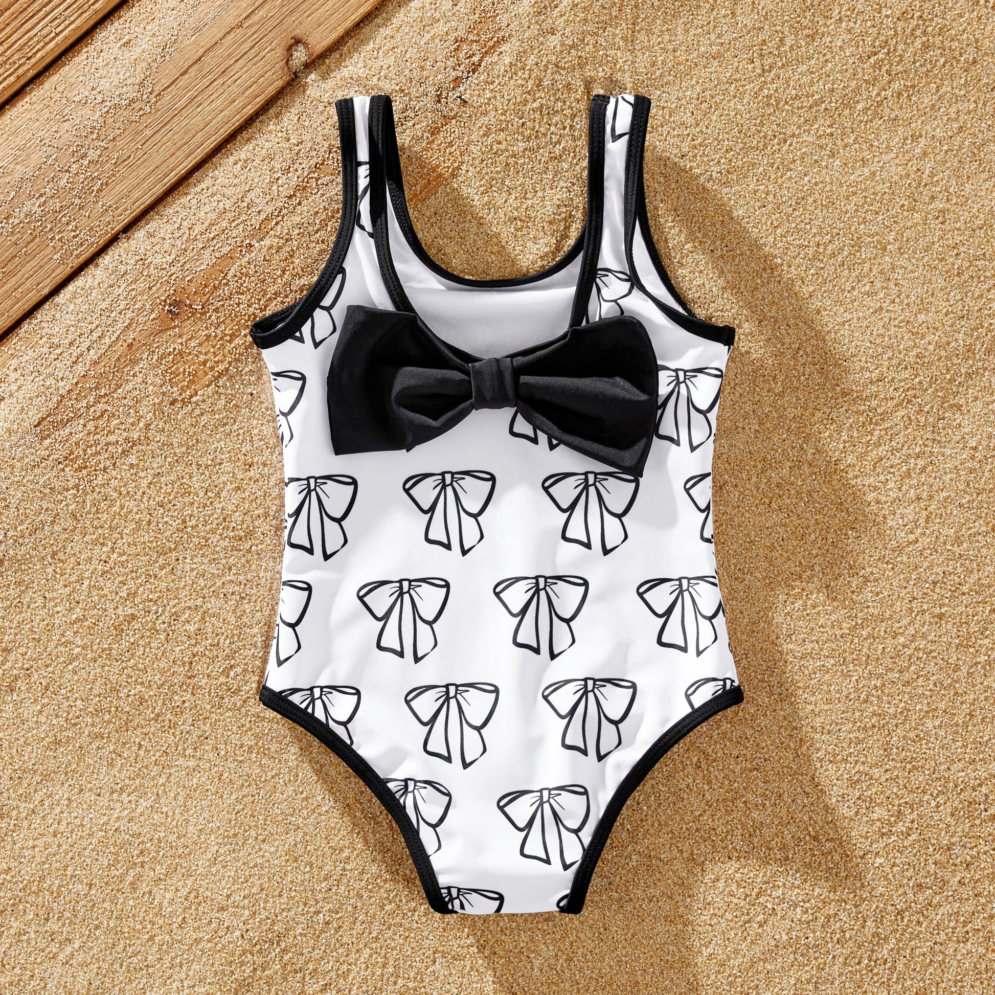 Full-length shot of a family posing in their matching white letter print swimwear.