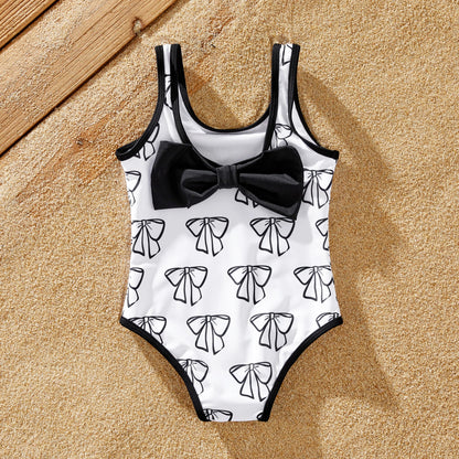 Full-length shot of a family posing in their matching white letter print swimwear.