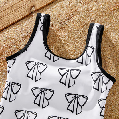 Back view of the white bow swimsuit, part of the family's matching beach attire.