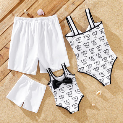 White mother & daughter bow swimsuit with family matching men's & boy's drawstring trunks.