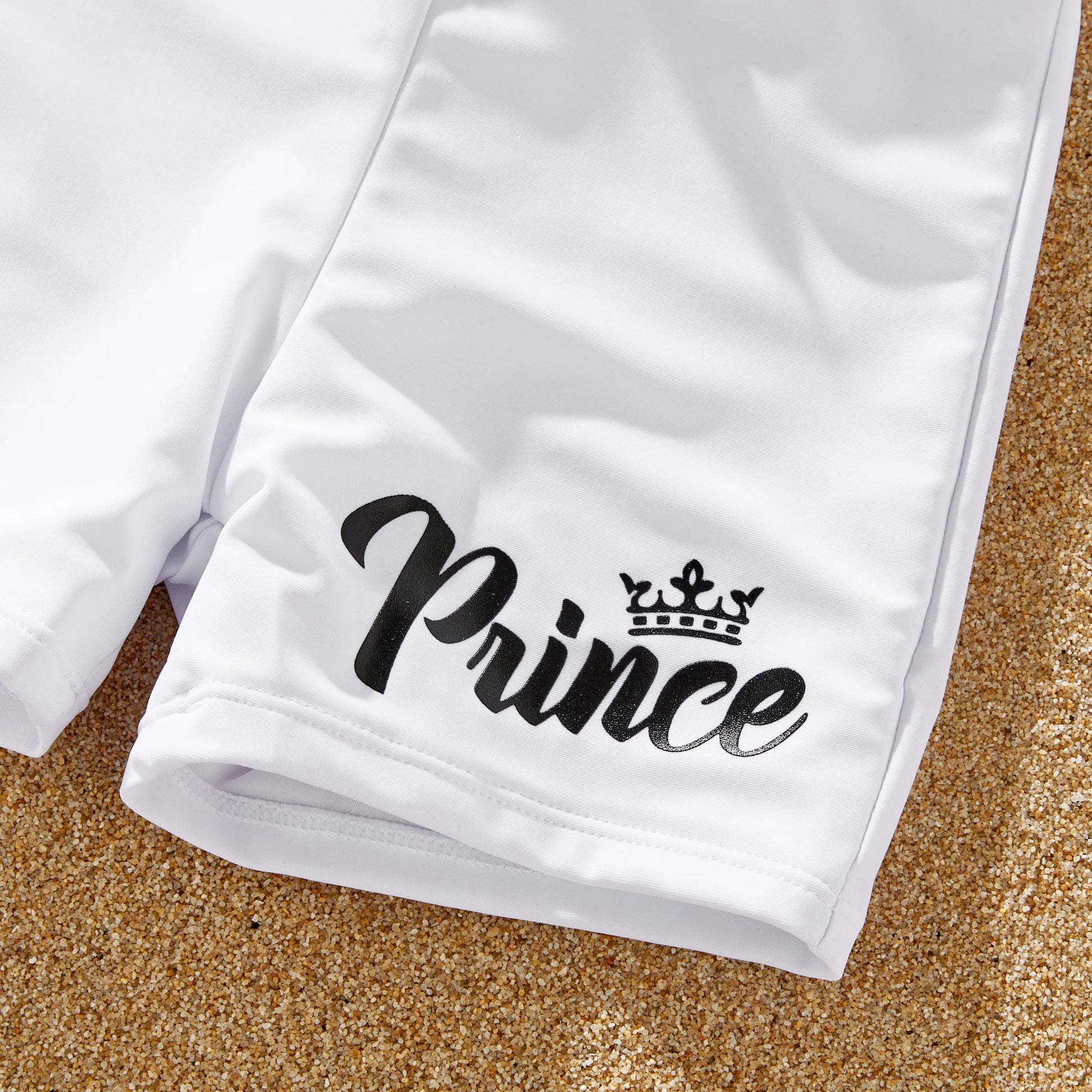 Close-up of white letter print bow swimsuit, part of a family matching swimwear set.