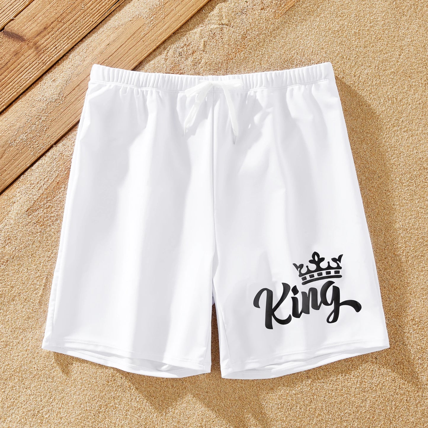 Family matching swimwear: white bow swimsuit for women, white drawstring trunks for men.