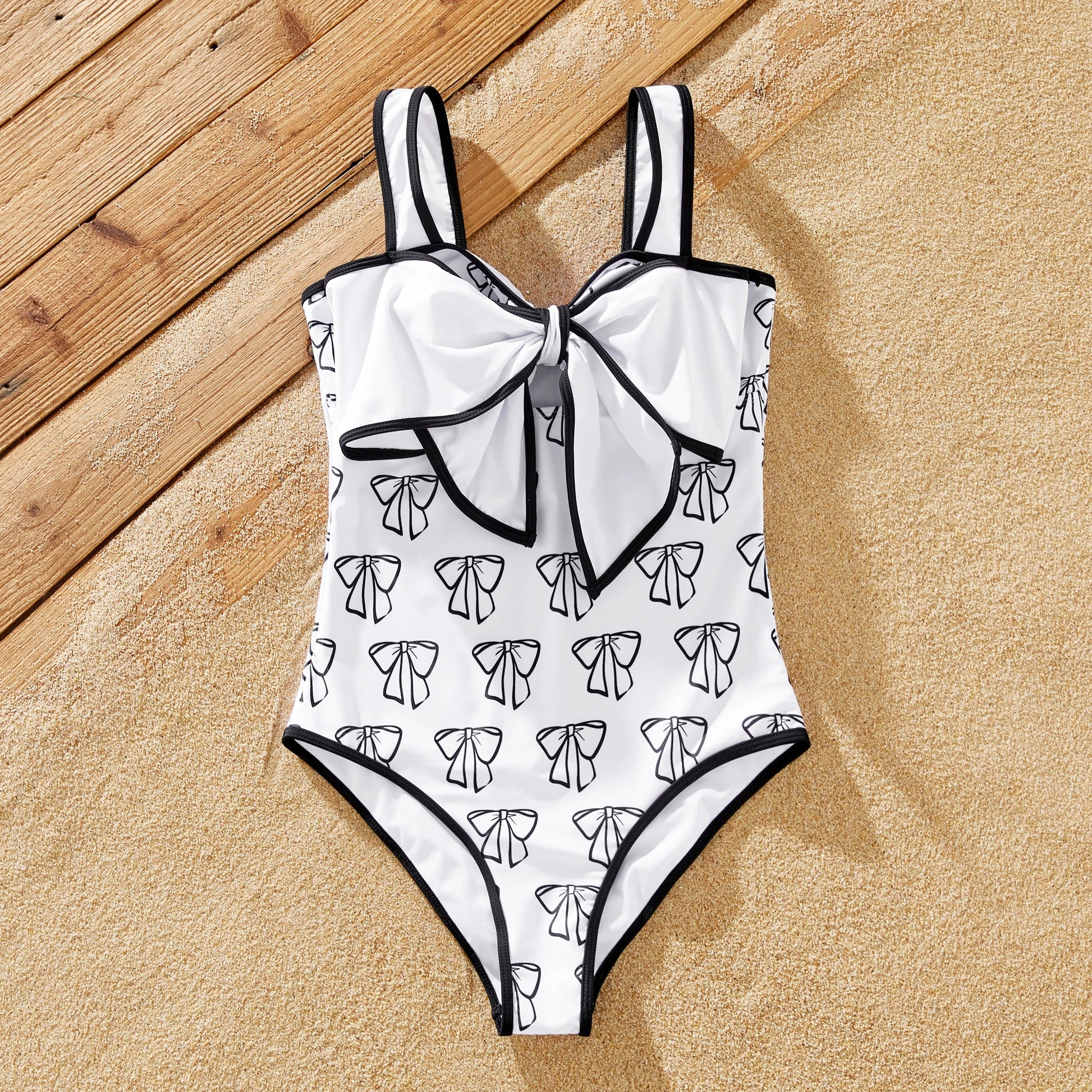 Stylish resort fashion with white family matching letter print swimsuits and trunks.