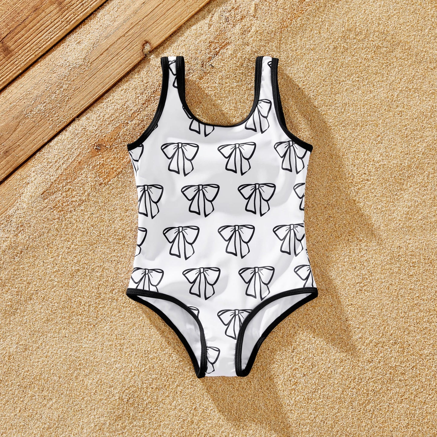 Cheerful family wearing matching white swimwear for a summer beach outing.