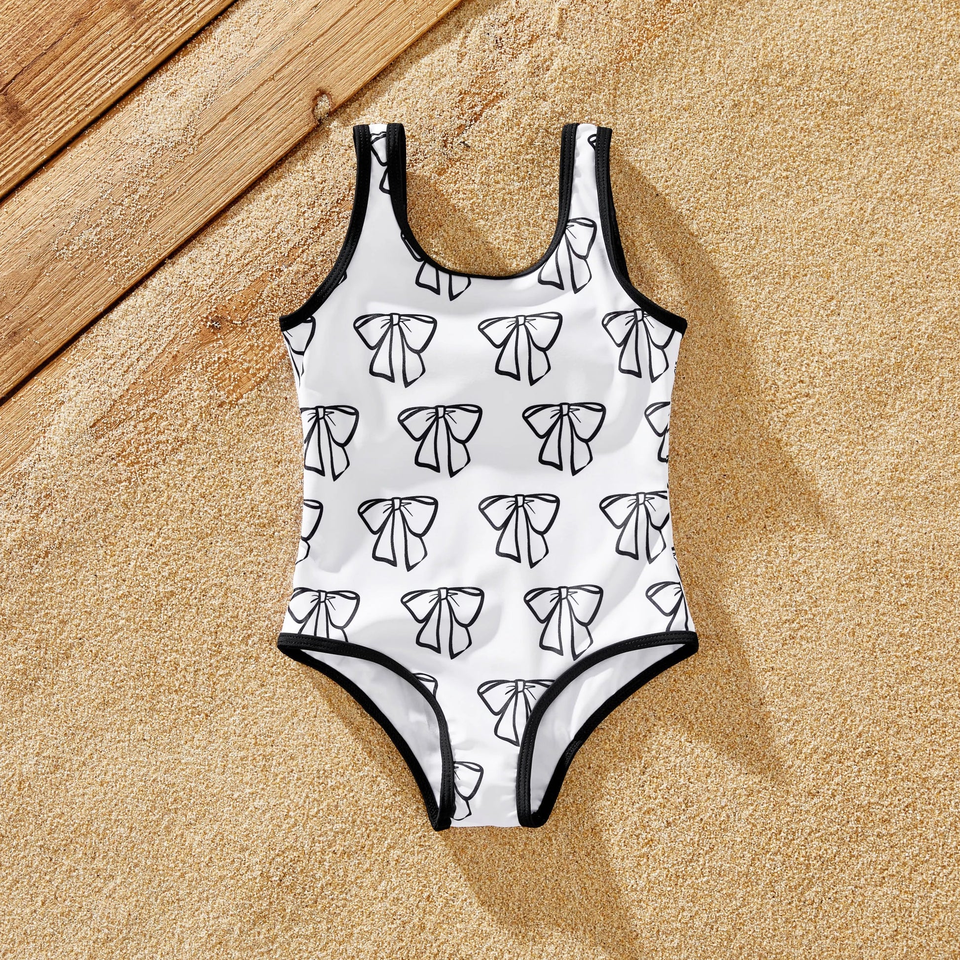 Cheerful family wearing matching white swimwear for a summer beach outing.