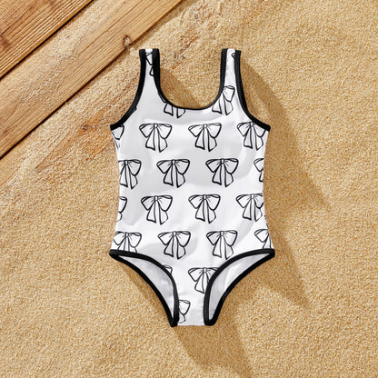 Cheerful family wearing matching white swimwear for a summer beach outing.