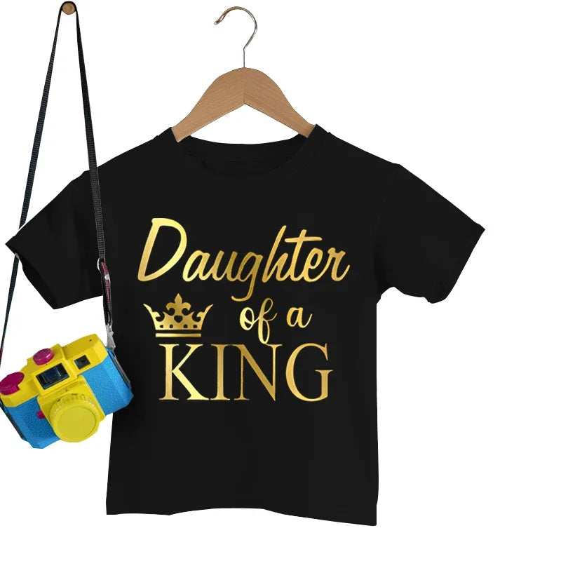 Dad and daughter wearing cute matching 'Princess King' graphic tees, family fun design.