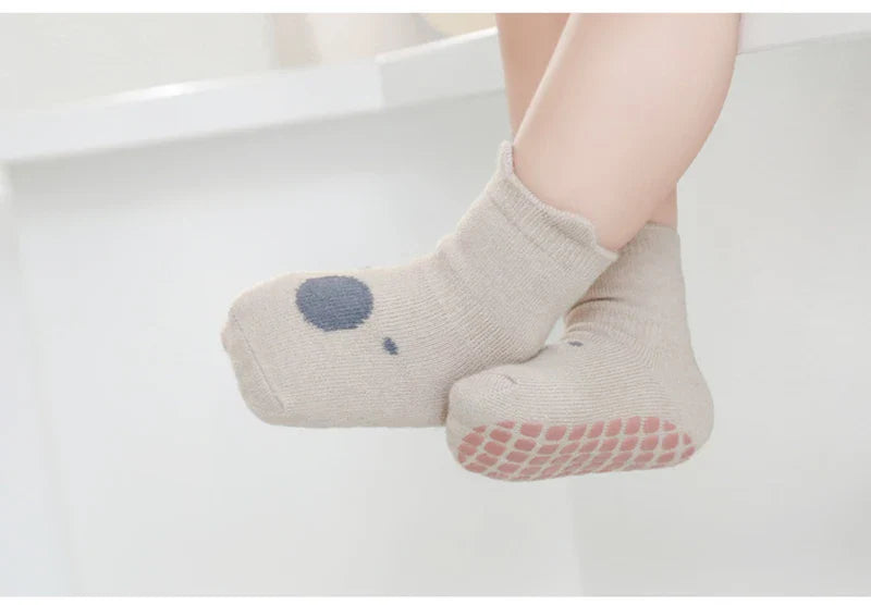 Overhead view of multiple pairs of anti-slip cartoon infant socks, neatly folded