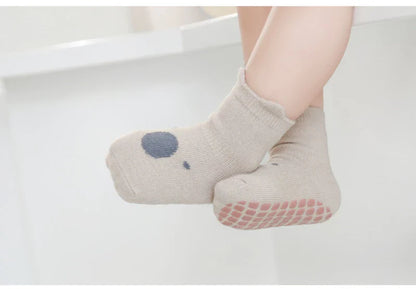 Overhead view of multiple pairs of anti-slip cartoon infant socks, neatly folded