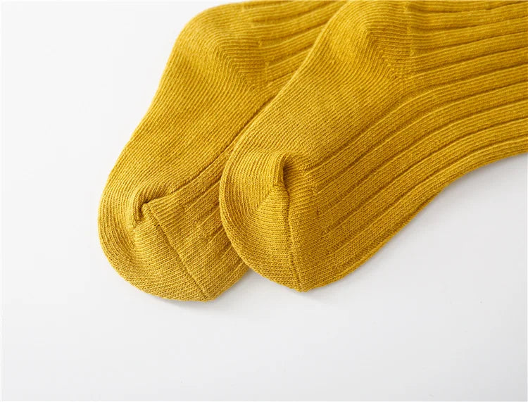 Neatly folded five pairs of cotton blend children's socks, featuring diverse colors.