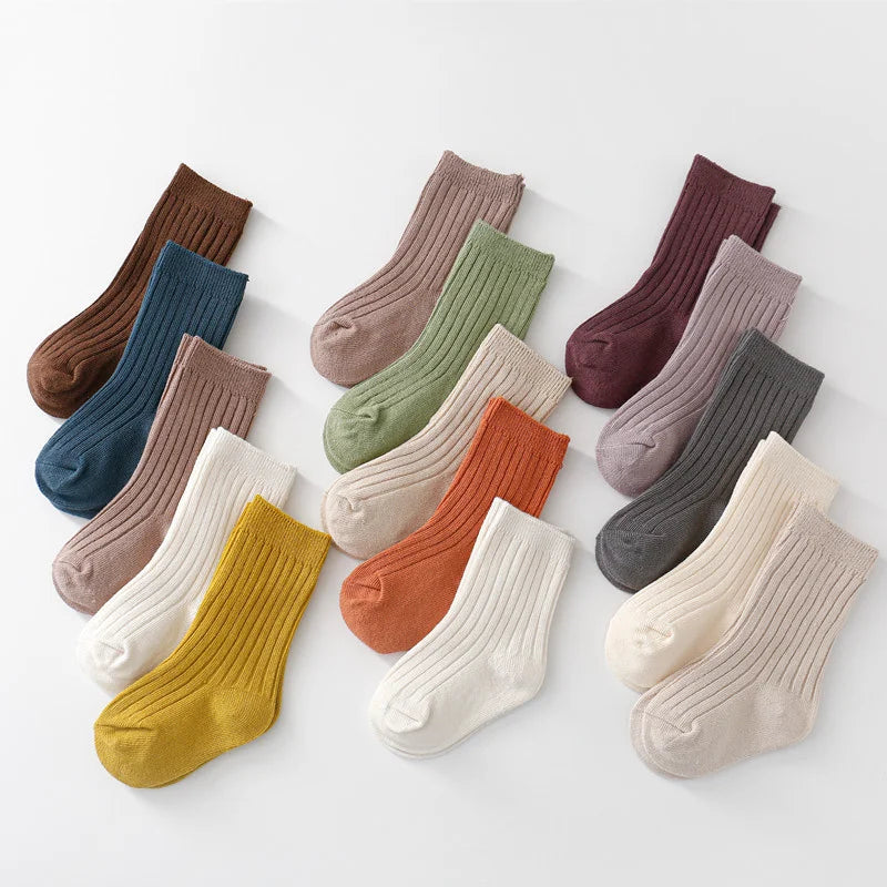 Close-up of a stack of five pairs of cotton blend children's socks in assorted colors.