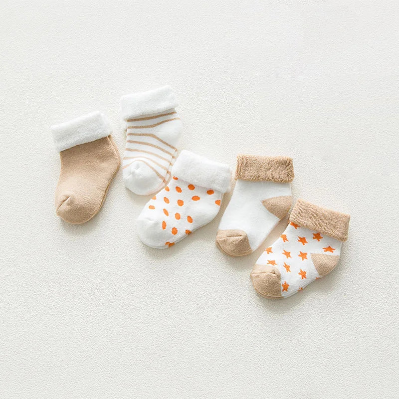 Five pairs of colorful, thick cotton baby socks with various cartoon patterns, newborn size.