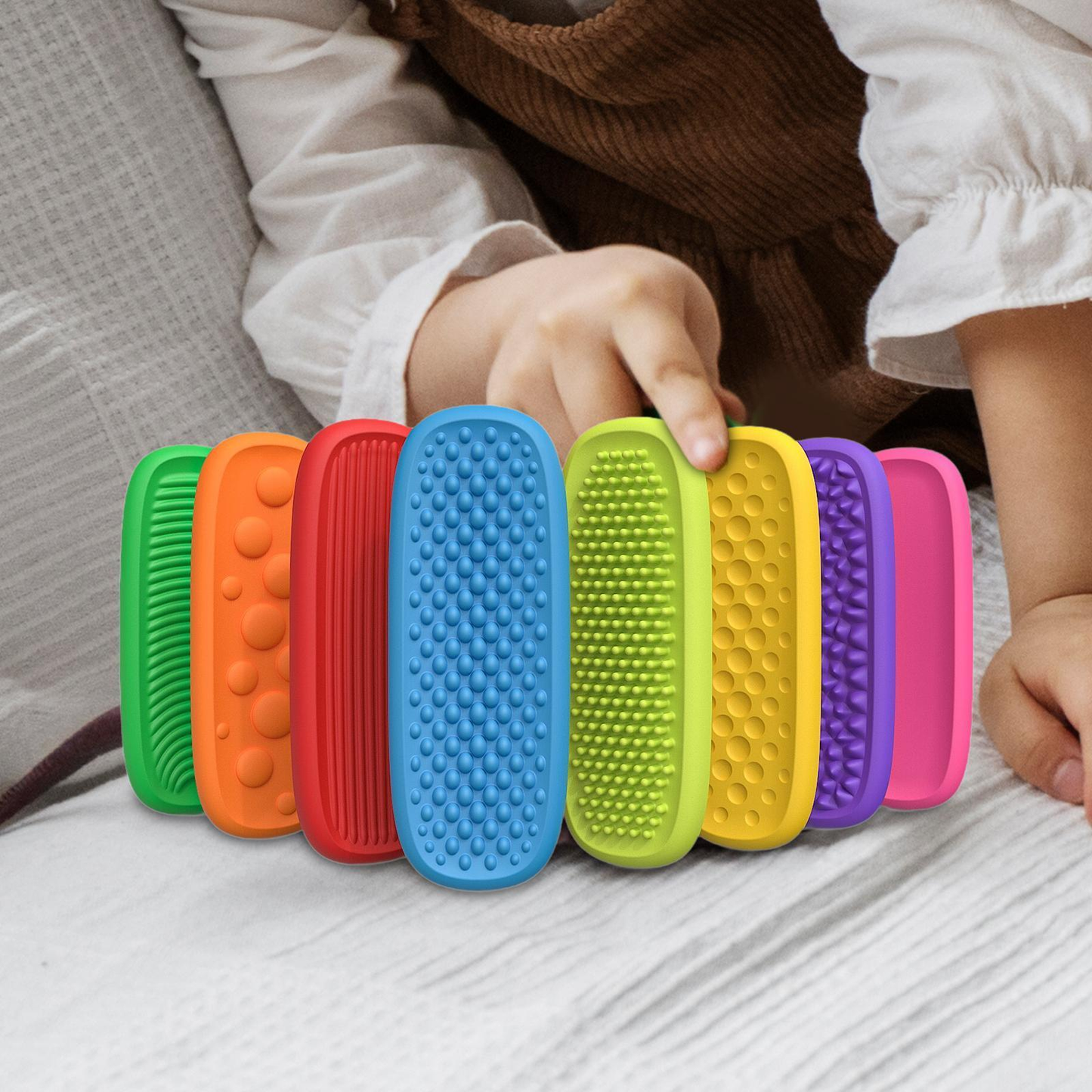 A child's hand gently touching a textured sensory strip, demonstrating its tactile quality for focus.