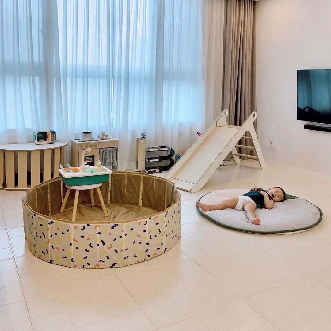 Toddler in a foldable PVC children's playpen with activity toys, ideal for baby's safe space