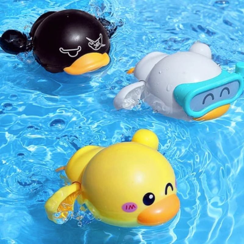Four colorful wind-up swimming bath ducks, yellow, green, blue, and pink, floating in water for toddler play.