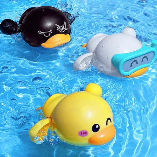 Four colorful wind-up swimming bath ducks, yellow, green, blue, and pink, floating in water for toddler play.