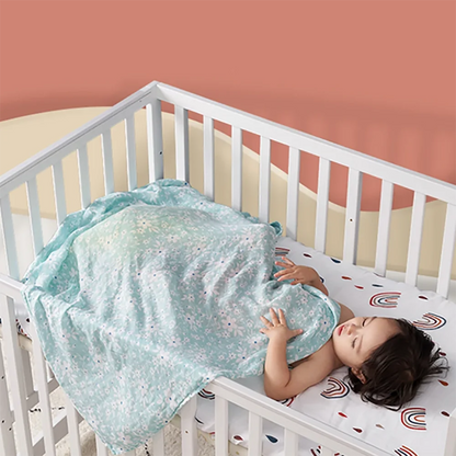 Close-up of a white bamboo cotton muslin swaddle blanket with subtle animal print, breathable