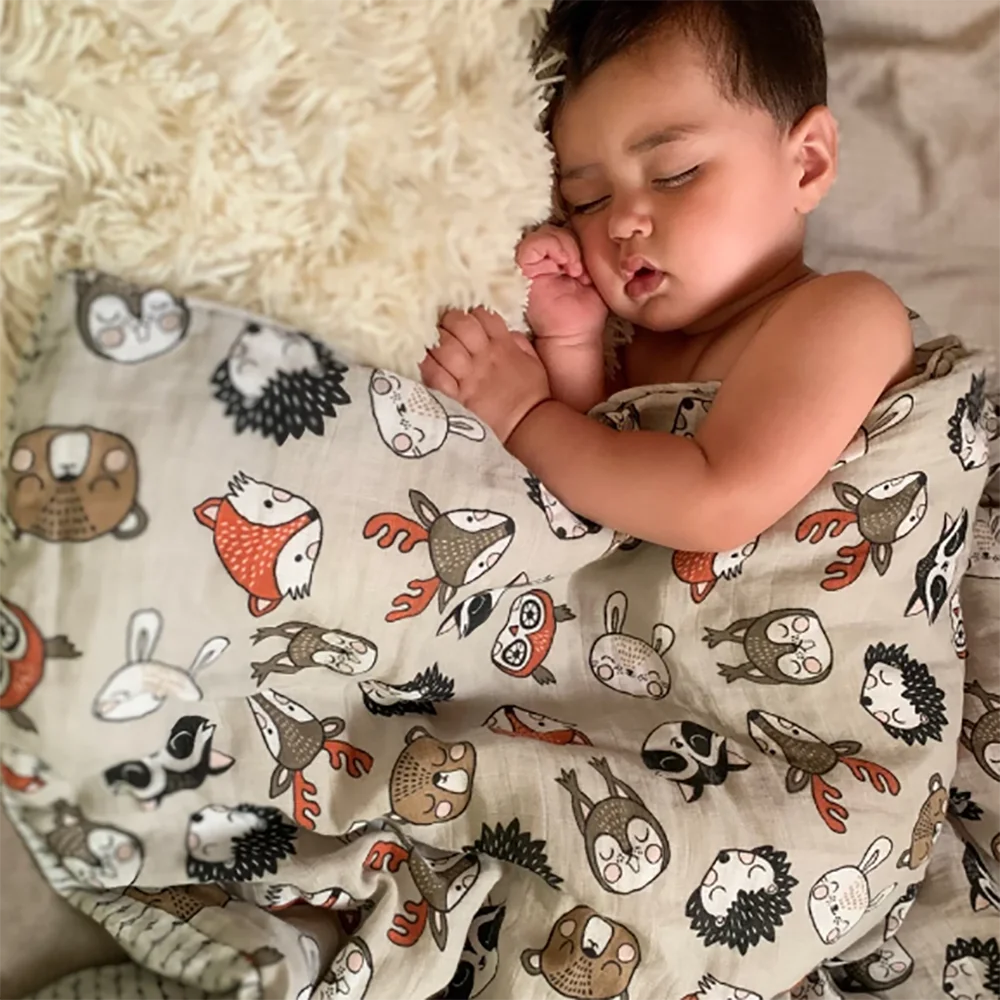 Baby wrapped comfortably in a multi-use bamboo cotton muslin swaddle blanket, soft infant care