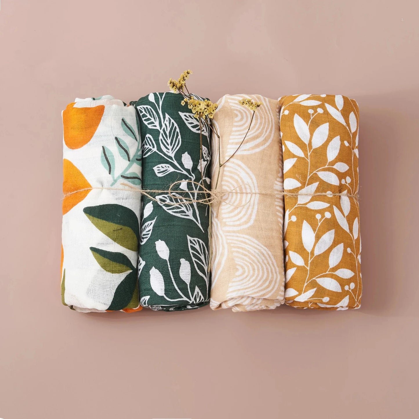 Newborn sleeping soundly, partially covered by a gentle bamboo cotton muslin swaddle blanket