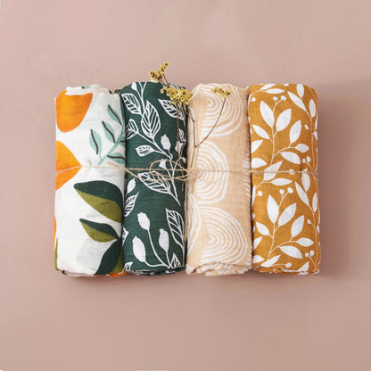 Newborn sleeping soundly, partially covered by a gentle bamboo cotton muslin swaddle blanket