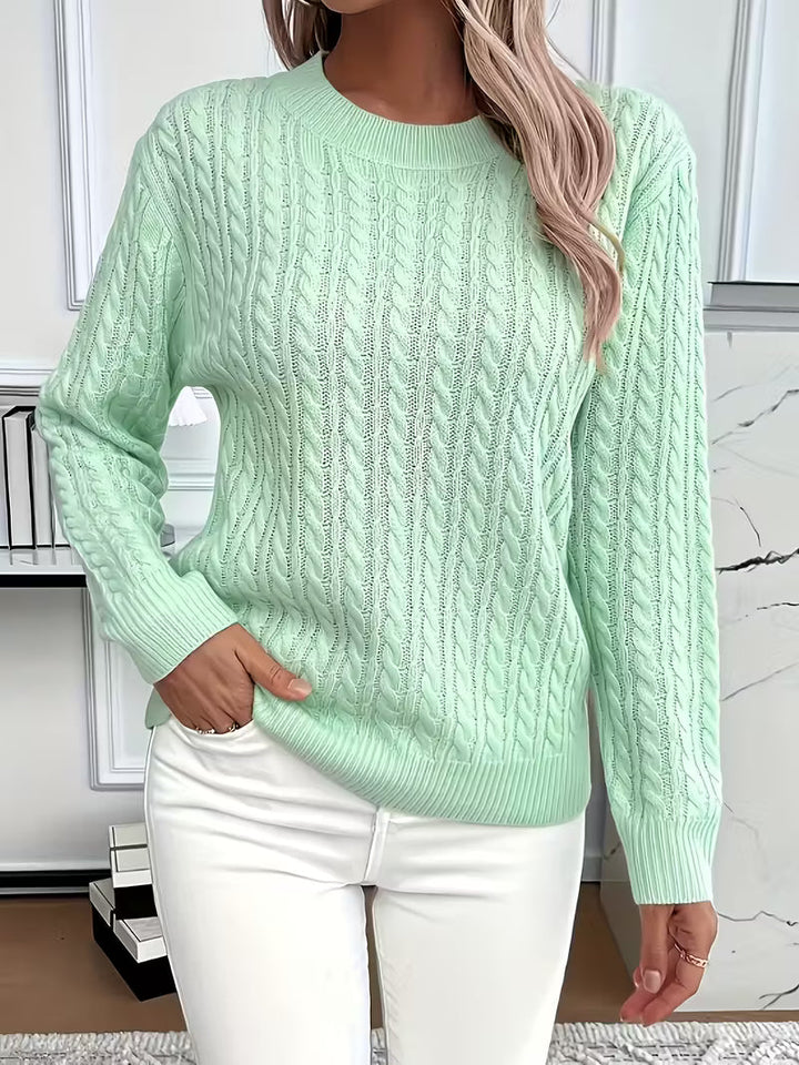 Close-up of the intricate cable knit pattern on a soft women's crew neck jumper, ideal for autumn.