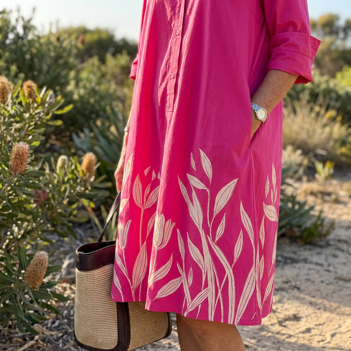 Elegant women's fuchsia midi shirt dress featuring beautiful floral embroidery. Ideal for a refined look.