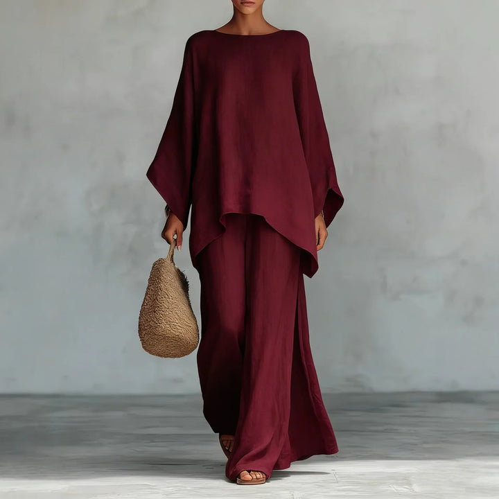 Woman modeling a chic two-piece women's set: an asymmetrical top & wide-leg pants. Versatile casual elegant outfit.