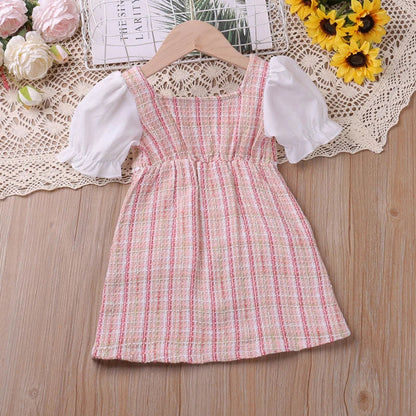 Toddler girl twirling in a pink plaid floral princess dress, ideal for summer parties.