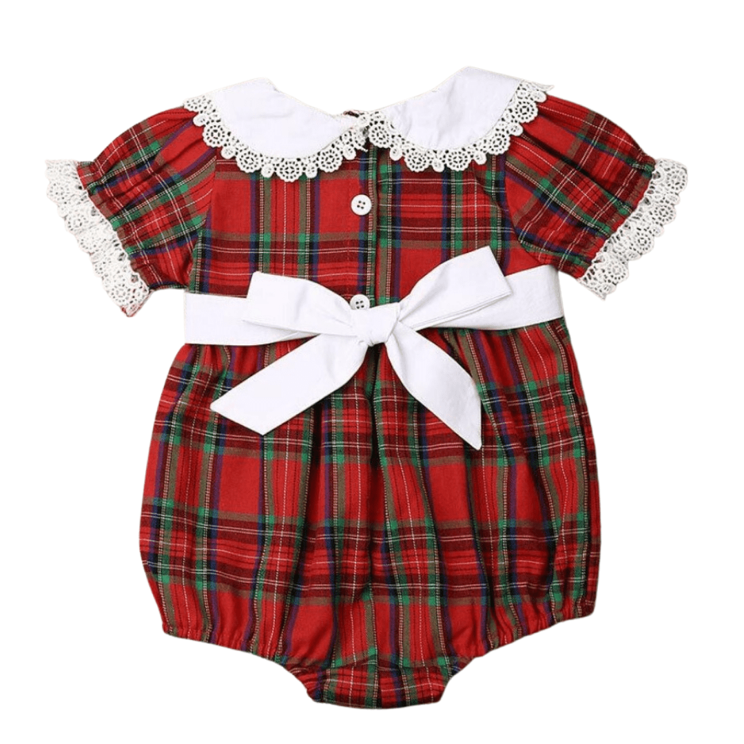 Close-up of the red and white plaid fabric on the girl's romper, showcasing soft cotton baby clothing.