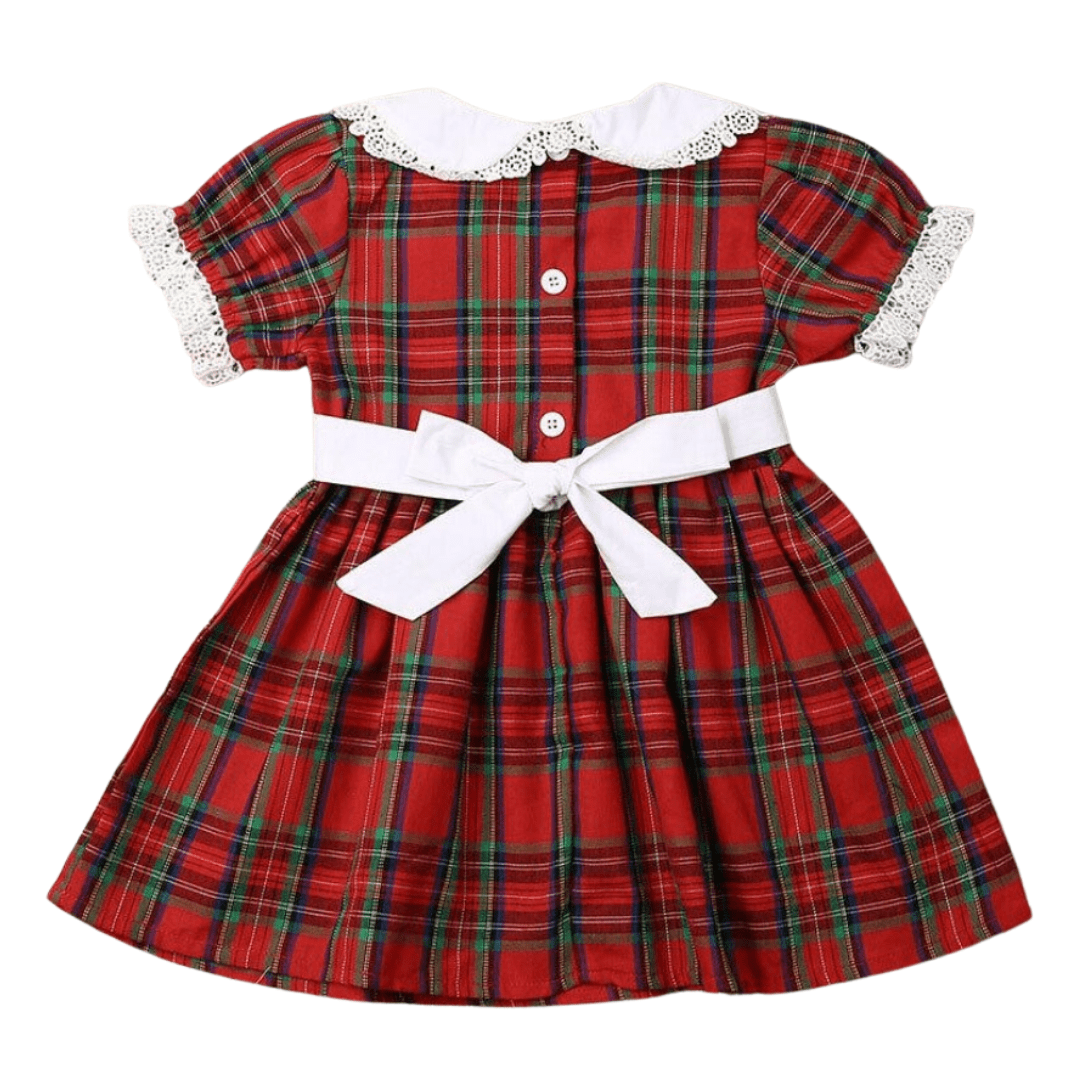 Girl in plaid dress and baby in plaid romper, matching sibling holiday outfits for festive occasions.