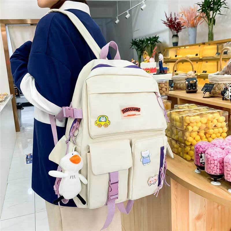Girls' 4-piece school backpack set in purple with floral design, showing backpack, tote, messenger bag, and pencil case.
