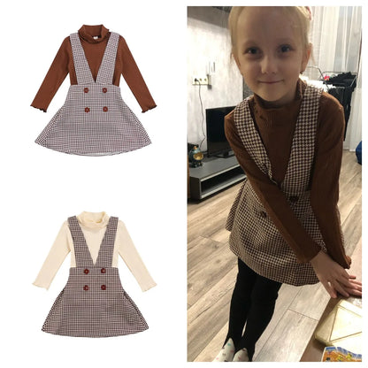 Children's autumn fashion set with a comfortable plain turtleneck and a brown, red, and blue plaid skirt.