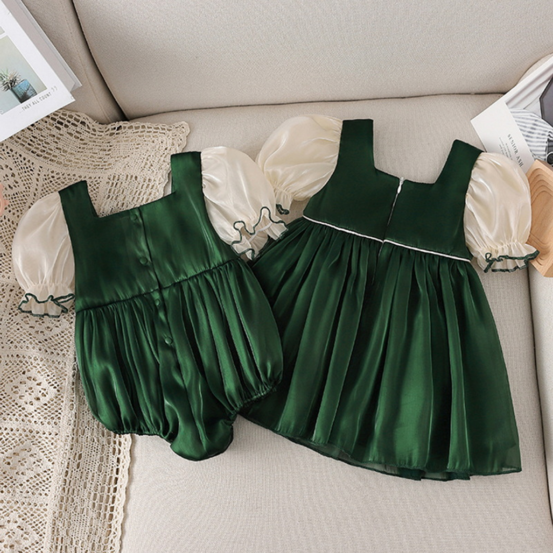 Baby girls' romper with puff sleeves and bow accent, coordinating with a dress for a complete outfit.
