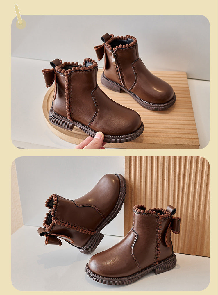 Childrens black faux leather ankle boot, close-up of zipper and stitching, robust and fashionable.
