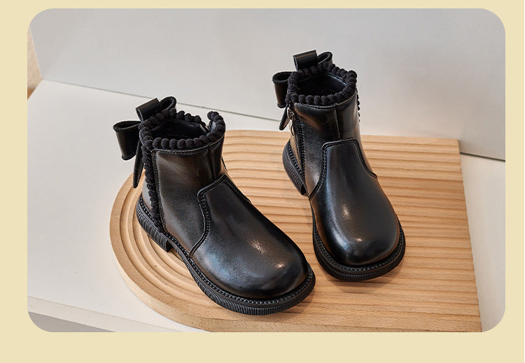 Close-up of a girl's brown faux leather ankle boot, showcasing the texture and sturdy sole.